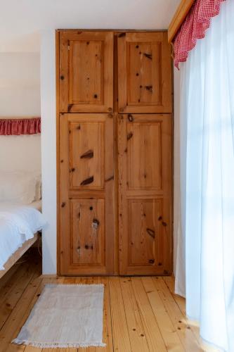 a bedroom with a wooden door and a bed at Guest Accommodation Butina in Kuterevo