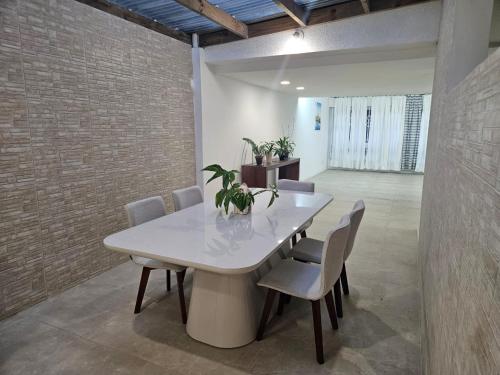 una sala da pranzo con tavolo e sedie bianchi di Espaço Semente Solar Jade a Porto Alegre