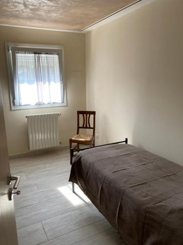 1 dormitorio con 1 cama, 1 silla y 1 ventana en Locazione Turistica da Cinzia 