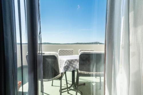 a table and chairs on a balcony with a view at Pension More in Šibenik