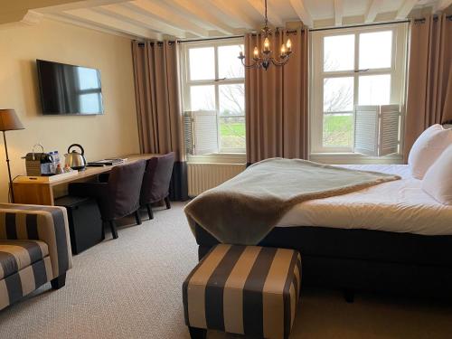 a bedroom with a bed and a desk and a table at Auberge de Campveerse Toren in Veere