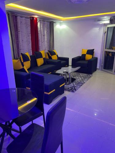 a living room with couches and a table with yellow pillows at Apex guest facility in Buea