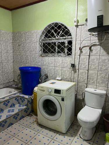 a bathroom with a washing machine and a toilet at Apex guest facility in Buea