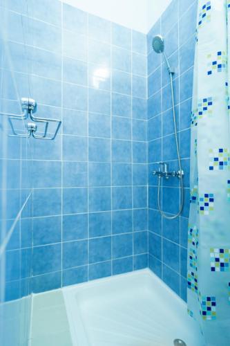 a blue tiled bathroom with a shower and a tub at Pension More in Šibenik