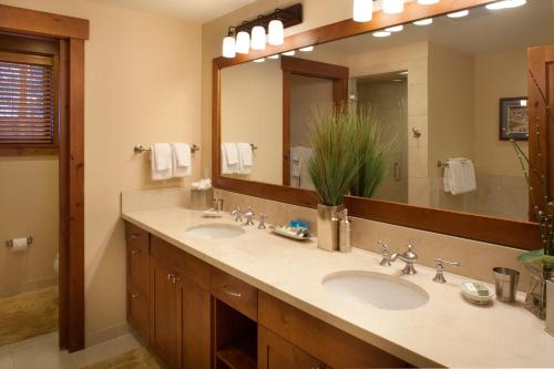 baño con 2 lavabos y espejo grande en Countryside at Snowmass - CoralTree Residence Collection, en Snowmass Village
