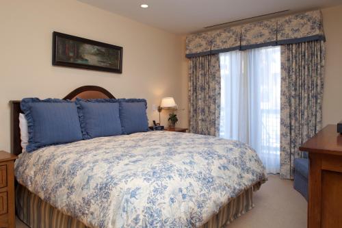 a bedroom with a bed and a window with curtains at Countryside at Snowmass - CoralTree Residence Collection in Snowmass Village