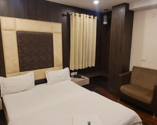 a bedroom with a white bed and a couch at HOTEL MERIDIAN in Jamshedpur