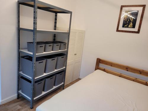 Cette chambre comprend un lit et une étagère avec des paniers. dans l'établissement Heart of City DE1 One Bedroom Apartment, à Derby