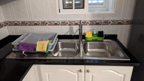 a kitchen sink with a dish drying rack next to it at Levada Nova House in Ribeira Brava