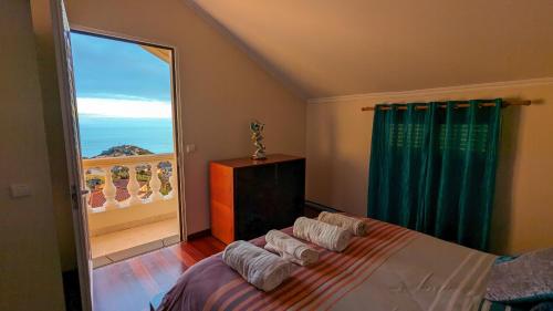 a bedroom with a bed and a large window at Levada Nova House in Ribeira Brava