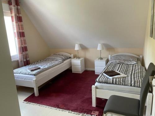 2 camas en una habitación pequeña con 2 lámparas en Diner Nord 2, en Ostercappeln