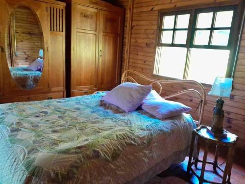 um quarto com uma cama num chalé de madeira em Terrinha Nosso Paraíso em São Carlos