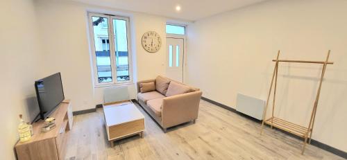 un salon avec un canapé et une télévision dans l'établissement Maison de ville avec Jardin 