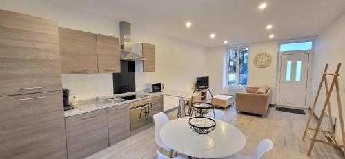 une cuisine et une salle à manger avec une table et des chaises dans l'établissement Maison de ville avec Jardin 