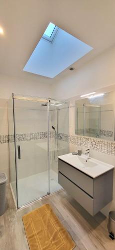 La salle de bains est pourvue d'une douche, d'un lavabo et d'une lucarne. dans l'établissement Maison de ville avec Jardin 