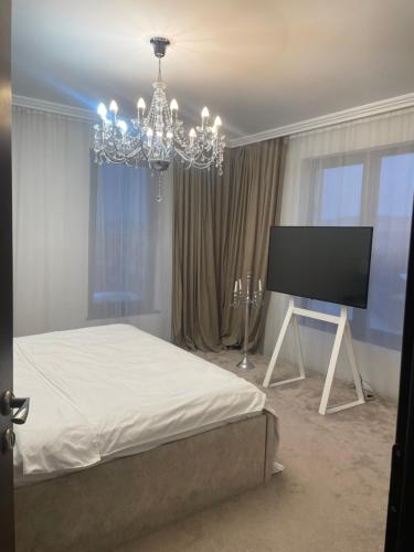 1 dormitorio con cama y lámpara de araña en Duke’s House en Bistriţa