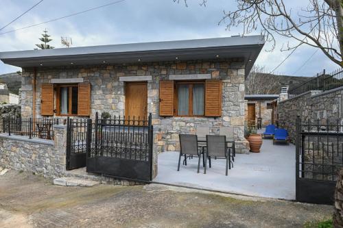 a stone house with a table and chairs in front of it at Mountain House Perampela in Nofaliás