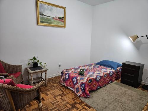 ein Schlafzimmer mit einem Bett, einer Lampe und einem Stuhl in der Unterkunft Espaço Semente Poa Violeta in Porto Alegre