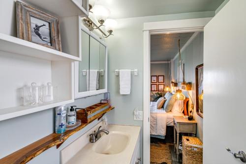 a bathroom with a sink and a bedroom with a bed at Cozy PNW Getaway with Fire Pit Walk to Beach! in Moclips