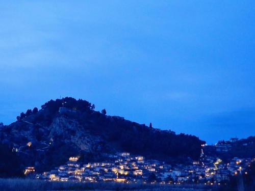una città su una collina di notte con una città di Apartaments Vila Mimani 2 a Berat