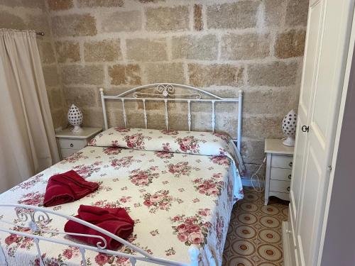 een slaapkamer met een bed met een bloemenbed bij BOUCANVILLE in Polignano a Mare