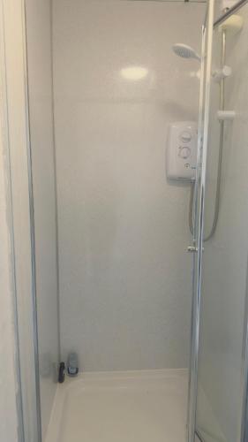 een douche met een glazen deur in de badkamer bij Budget Rooms in Fort William