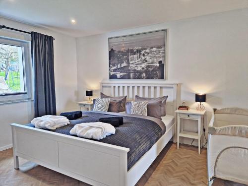 1 dormitorio con 1 cama con 2 almohadas en FeelGood 212 qm Ferienhaus mit 2 Apartments - Garten, Grill & Sauna!, en Schauenburg