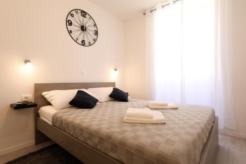 a bedroom with a bed with a large clock on the wall at Piccola Pyrotima in Zadar