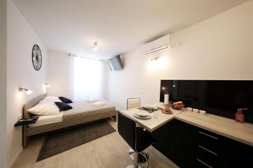 a small bedroom with a bed and a large television at Piccola Pyrotima in Zadar