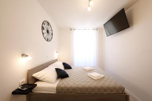 a bedroom with a bed with a clock on the wall at Piccola Pyrotima in Zadar