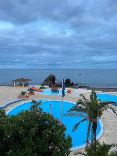 a resort with two swimming pools and a beach at Esplanada do Ilhéu in Vila Franca do Campo