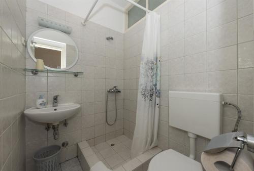 a bathroom with a sink and a toilet and a shower at Apartment and Rooms Amenka in Novalja