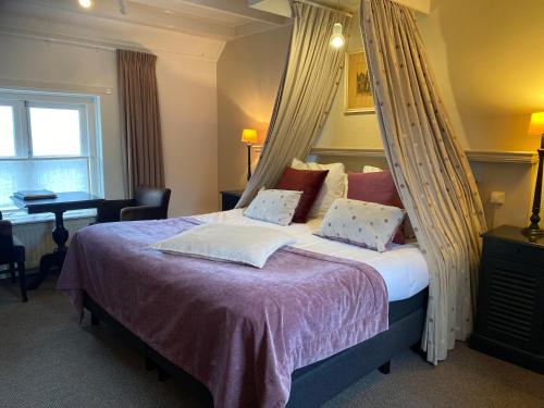 a bedroom with a bed with a canopy at Auberge de Campveerse Toren in Veere