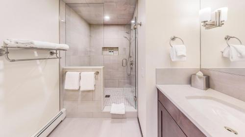 a white bathroom with a shower and a sink at Willows - CoralTree Residence Collection in Snowmass Village