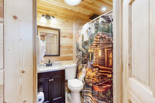uma casa de banho com um WC e um lavatório em Log Cabin Life em Arkdale