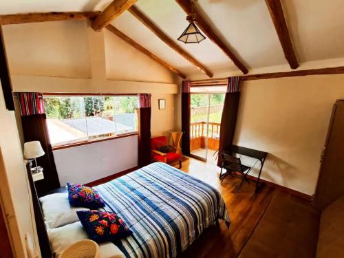 1 dormitorio con cama y ventana grande en Cabaña del Rey en Cuzco
