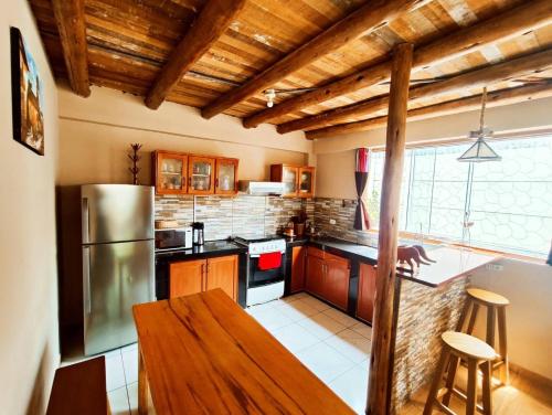 cocina con armarios de madera y mesa de madera en Cabaña del Rey en Cuzco