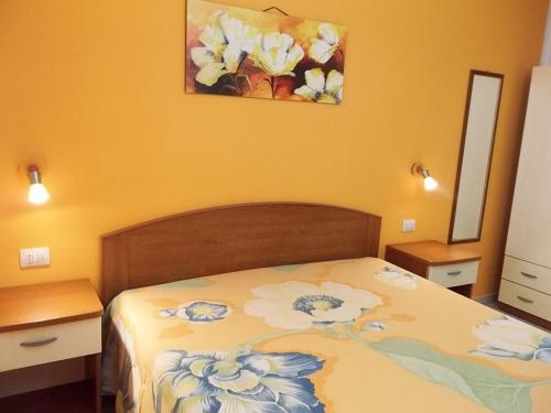トッレ・スペッキア・ルッジェーリにあるVilla Mare del Salentoのベッドルーム1室(ベッド1台付)が備わります。壁には絵画が飾られています。
