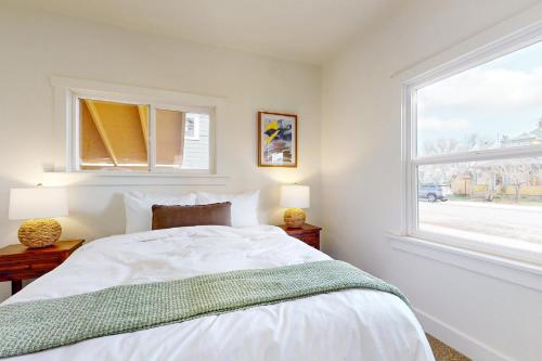 a white bedroom with a bed and a window at Fountain District Bungalow in Bellingham