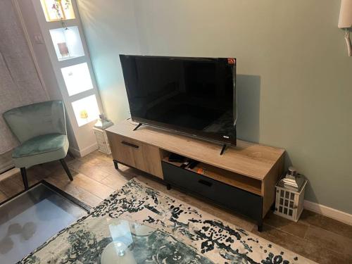 a living room with a flat screen tv and a chair at Souplex bordeaux gare saint jean in Bordeaux