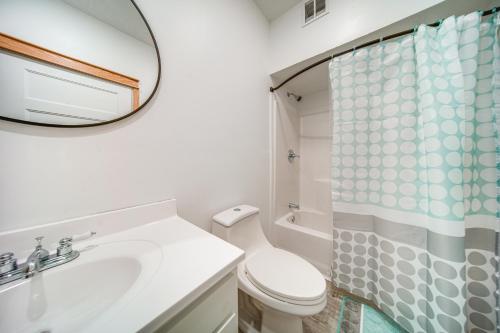 a white bathroom with a sink and a mirror at Welcoming Erie Condo with Golf and Lake Views! in Erie