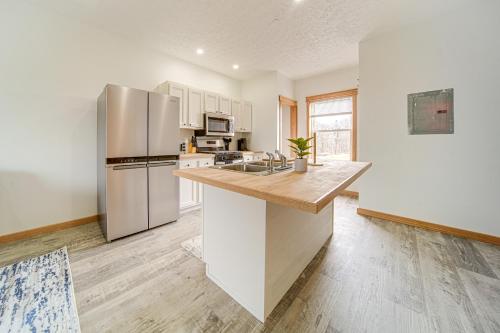 a kitchen with white cabinets and a stainless steel refrigerator at 4 Mi to Lake Erie Condo with Golf Course Views! in Erie