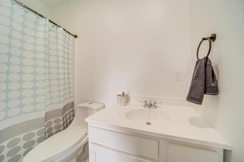 a white bathroom with a sink and a shower at Erie Condo about 4 Mi to Lake with Golf Course Views! in Erie