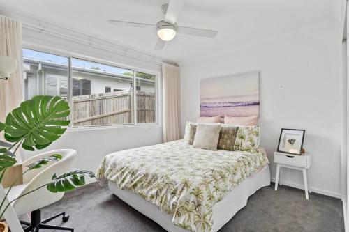 a white bedroom with a bed and a window at Valley Way in Lennox Head