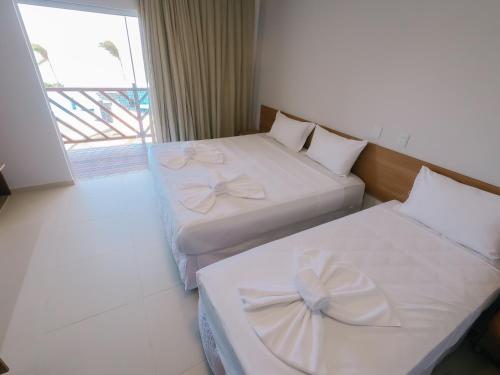- 2 lits dans une chambre d'hôtel avec des arcs dans l'établissement Oiti Beach Resort Tutoia, à Tutóia