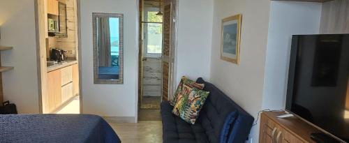 um quarto com um sofá, uma televisão e uma cozinha em Casa Luna Laguna Beach em Tolú
