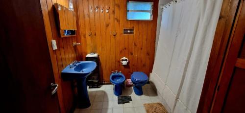 a bathroom with a blue sink and a toilet at Casa completa para 5 personas. in San Carlos de Bariloche