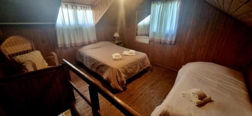 a small room with two beds and a mirror at Casa completa para 5 personas. in San Carlos de Bariloche