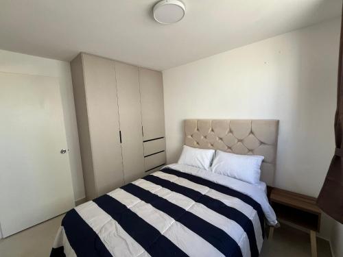 a bedroom with a black and white striped bed at Casa V25 in Querétaro