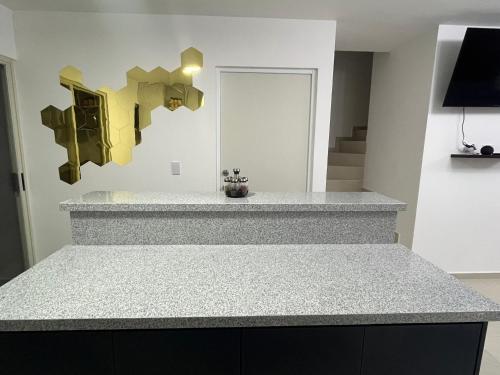 a kitchen with a granite counter top and yellow sculptures at Casa V25 in Querétaro